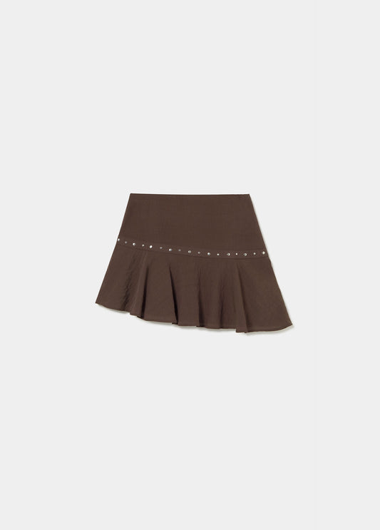 Falda corta bajo asimétrico tachas